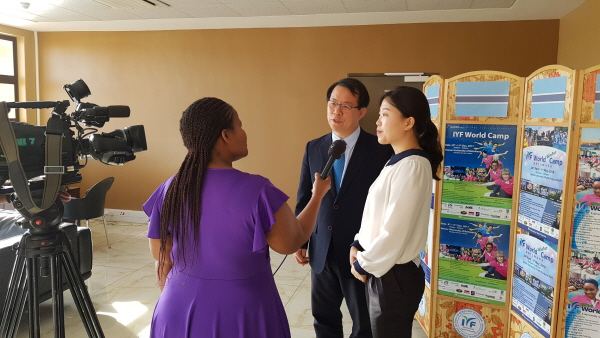 A TV interview with IYF guests in front of a camera.