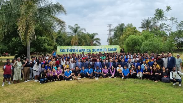 Youth gathered on the grass under a Southern Africa Summer Camp banner.