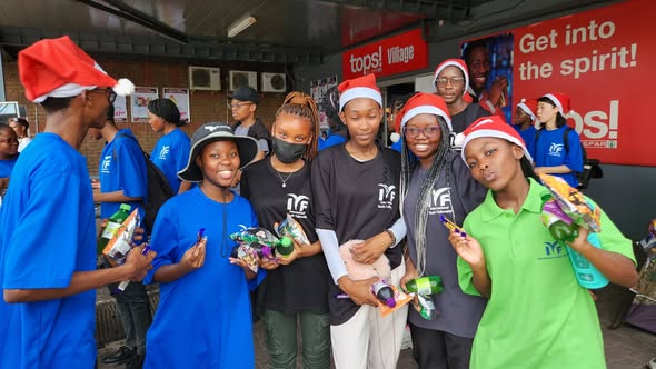 IYF members in Santa hats holding small gifts.